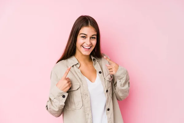 Mulher Branca Jovem Posando Fundo Rosa Sorri Apontando Dedos Para — Fotografia de Stock