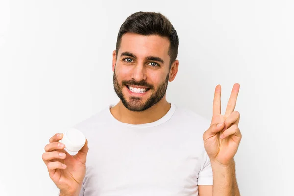 Young Caucasian Man Holding Moisturizer Isolated Showing Number Two Fingers — Stock Photo, Image