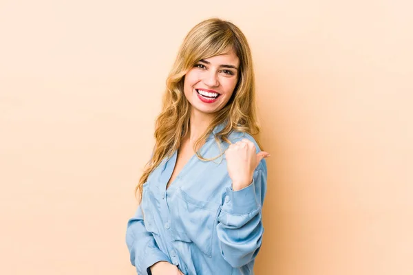Young Blonde Caucasian Woman Points Thumb Finger Away Laughing Carefree — Stock Photo, Image