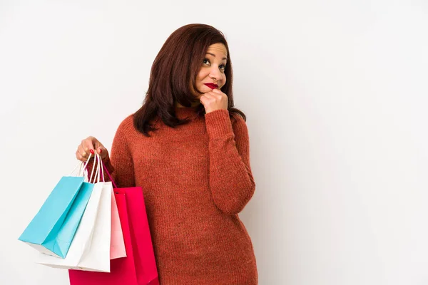 Medelålders Latinamerikansk Kvinna Som Håller Shoppingpåse Isolerad Tittar Sidled Med — Stockfoto