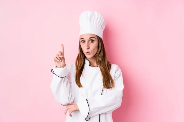 Young caucasian chef woman isolated having some great idea, concept of creativity.