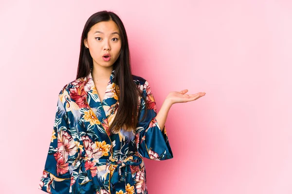 Joven Mujer China Con Pijama Kimono Aislado Impresionado Sosteniendo Espacio —  Fotos de Stock