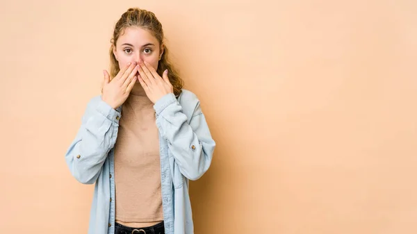 Mujer Joven Caucásica Aislada Sobre Fondo Beige Impactada Cubriendo Boca —  Fotos de Stock