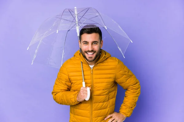 年轻英俊的男人拿着一把雨伞 孤零零地笑着 玩得很开心 — 图库照片