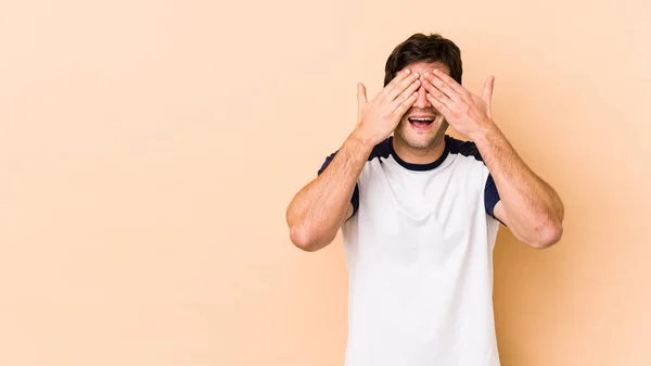 Ung Man Isolerad Beige Bakgrund Täcker Ögon Med Händer Ler — Stockfoto