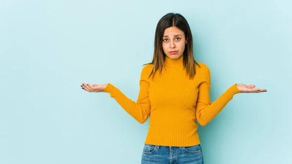 Junge Frau Auf Blauem Hintergrund Zweifelnd Und Achselzuckend Fragender Geste — Stockfoto