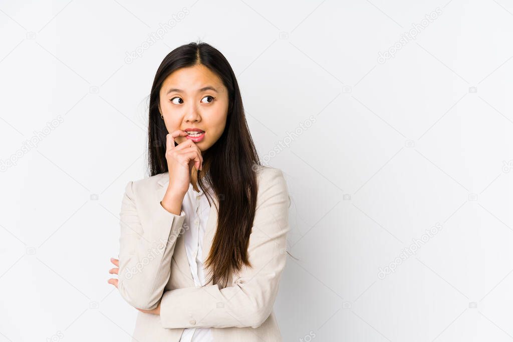Young business chinese woman isolated relaxed thinking about something looking at a copy space.