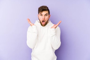 Mor arka planda izole genç beyaz adam şaşırdı ve şok oldu..