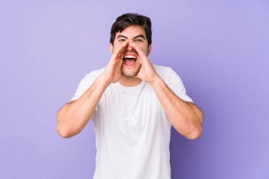 Mor arka planda izole edilmiş genç bir adam heyecanlı bir şekilde bağırıyor..
