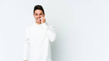 Beyaz arka planda izole edilmiş, tırnak yiyen, gergin ve endişeli genç bir beyaz adam..