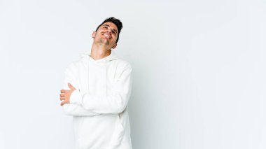 Beyaz arka planda izole edilmiş genç beyaz adam hedeflere ve amaçlara ulaşmayı hayal ediyor.