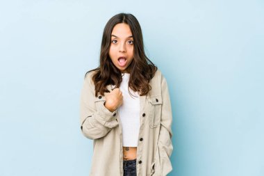 Genç, melez İspanyol bir kadın izole edilmiş. Parmakla işaret ederek şaşırmış, geniş bir gülümsemeyle..