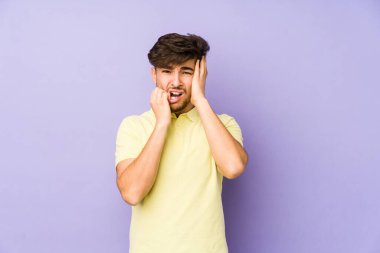 Mor bir arka planda, ağlayan ve sızlanan genç bir Arap..