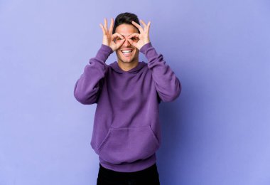 Mor arka planda izole edilmiş genç beyaz adam heyecanlı..