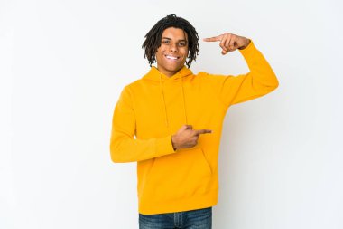 Genç Afrikalı Amerikalı Rasta adam işaret parmaklarıyla küçük bir şey tutuyor, gülümsüyor ve kendinden emin..