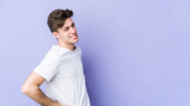 Mor arka planda izole edilmiş beyaz bir adam sırt ağrısı çekiyor..