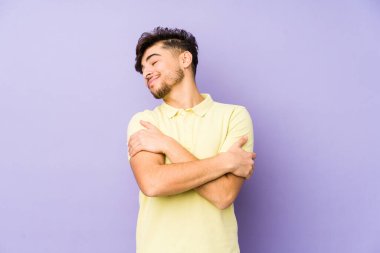 Mor arka planda yaşayan genç bir Arap adam. Kucaklaşma, kaygısız gülümseme ve mutluluk..