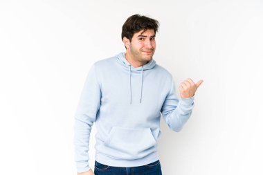 Beyaz arka planda izole edilmiş genç adam işaret parmağıyla bir kopyalama alanını işaret ederek şok oldu..