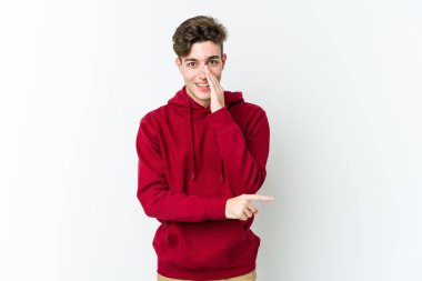 Beyaz arka planda izole edilmiş genç beyaz bir adam bir dedikodu söylüyor, bir haber sunuyor..