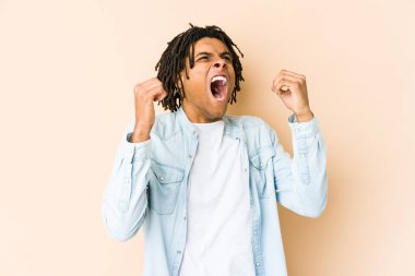 Genç Afrikalı Amerikalı Rasta adam zafer ve galibiyet kavramından sonra yumruğunu kaldırıyor..