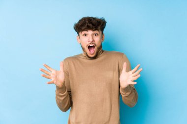 Genç Arap bir adam zaferi ya da başarıyı kutluyor, şaşırıyor ve şok oluyor..