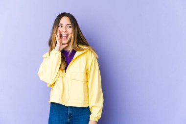 Mor arka planda izole edilmiş beyaz bir kadın heyecanlı bir şekilde bağırıyor..