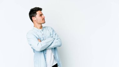 Beyaz arka planda izole edilmiş genç beyaz adam hedeflere ve amaçlara ulaşmayı hayal ediyor.