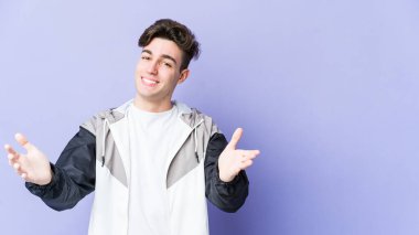 Mor arka planda izole edilmiş beyaz bir genç hoş bir yüz ifadesi sergiliyor..