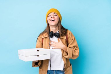 Kafkasyalı genç bir kadın pizzaları tek başına tutuyor kahkahalar atıyor ve elini göğsüne koyuyor.