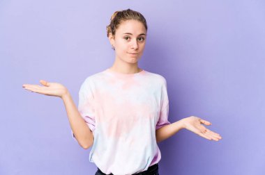 Mor arka planda beyaz bir kadın. Kopya alanını tutmak için omuz silkiyor ve kafası karışık..