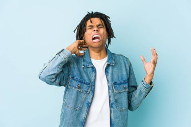 Kot ceket giyen genç siyah adam öfkeyle bağırıyor..