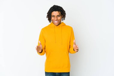 Genç Afrikalı Amerikalı Rasta adam iki eliyle bir şey tutuyor, ürün sunumu..