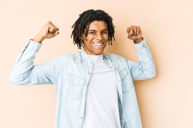 Genç Afrikalı Amerikalı Rasta adam güçlü bir jest yapıyor, kadınsı gücün sembolü.