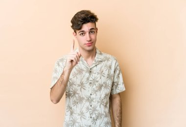 Beyazlı genç bir adam bej arka planda izole edilmiş. Parmak izi 1 numara..