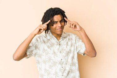 Genç Afrikalı Amerikalı Rasta adam bir işe odaklanmış, parmaklarını işaret ediyor..