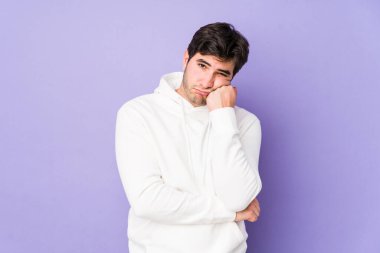 Mor arka planda izole edilmiş, üzgün ve dalgın hisseden, kopyalama alanına bakan genç adam..