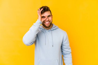 Kafkasyalı genç adam sarı arka planda izole edilmiş. Heyecanlı..