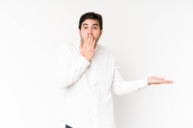 Beyaz arka planda izole edilmiş genç adam, avuç içinde kopya alanı tutmaktan etkilenmiş..