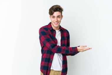 Beyaz arka planda izole edilmiş beyaz tenli genç bir adam palmiyesinde bir kopya alanı tutuyor..