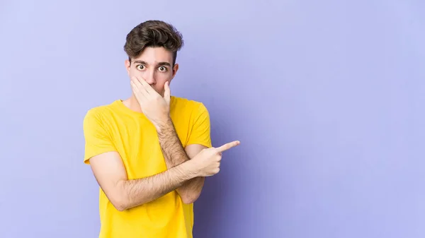 Joven Hombre Caucásico Aislado Sobre Fondo Púrpura Apuntando Hacia Lado —  Fotos de Stock