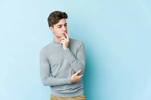 Young Caucasian Man Isolated Blue Background Looking Sideways Doubtful Skeptical — Stock Photo, Image