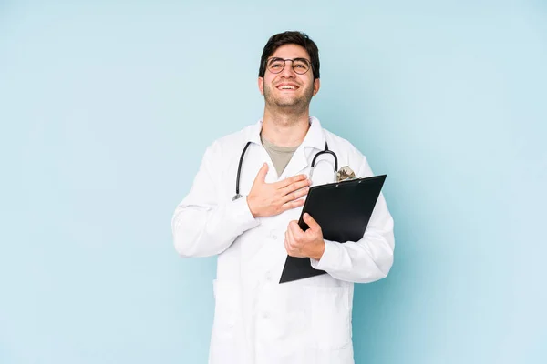 Junger Arzt Auf Blauem Hintergrund Lacht Laut Aus Und Hält — Stockfoto