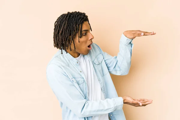 Jovem Afro Americano Rasta Homem Chocado Surpreso Segurando Espaço Cópia — Fotografia de Stock