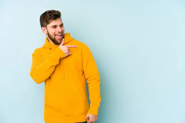 Jovem Caucasiano Isolado Fundo Azul Olha Para Lado Sorridente Alegre — Fotografia de Stock