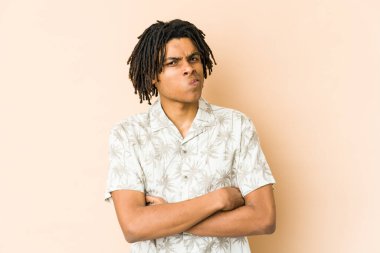 Afro-Amerikan Rasta 'lı genç adam hoşnutsuzca kaşlarını çatıyor, kollarını kavuşturuyor..