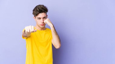 Morarmış arka planda izole olmuş genç beyaz bir adam bir tartışma yüzünden yumruk atıyor, sinirleniyor ve kavga ediyor..