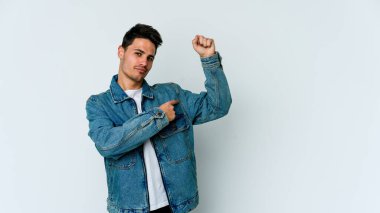 Beyaz arka planda izole edilmiş genç beyaz bir adam güçlü bir hareket gösteriyor, kollarıyla, kadınsı gücün sembolü.