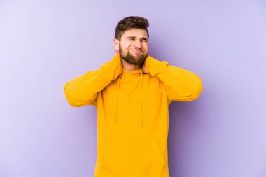 Mor arka planda izole edilmiş genç bir adam sabit yaşam tarzından dolayı boyun ağrısı çekiyor..