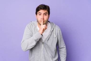 Mor arka planda izole edilmiş genç bir adam ya sır saklıyor ya da sessizlik istiyor..