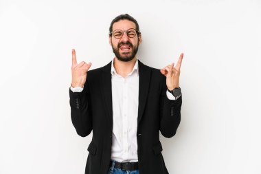 Beyaz arka planda izole genç beyaz iş adamı parmaklarıyla kaya jestleri gösteriyor